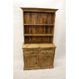 A pine dresser, with open top over two short drawers and a pair of panel doors, 107 cm wide x 198 cm
