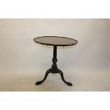 A 19th Century mahogany Irish snap top tripod table, with pie crust top supported on a column over