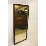 A 19th Century mahogany veneered mirror, of rectangular form with shaped outline and gilt mount, 138