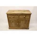 A pine sideboard, two short drawers over a pair of panelled doors, on plinth base 102 cm x 86 cm