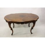 A 19th Century French walnut oval hall table, the shaped quarter veneered top with carved and