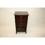 An early 20th Century stained beech music cabinet, fitted with five fall front drawers above