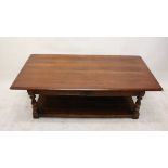 A modern oak low coffee table, of rectangular form with frieze drawers, turned supports united by