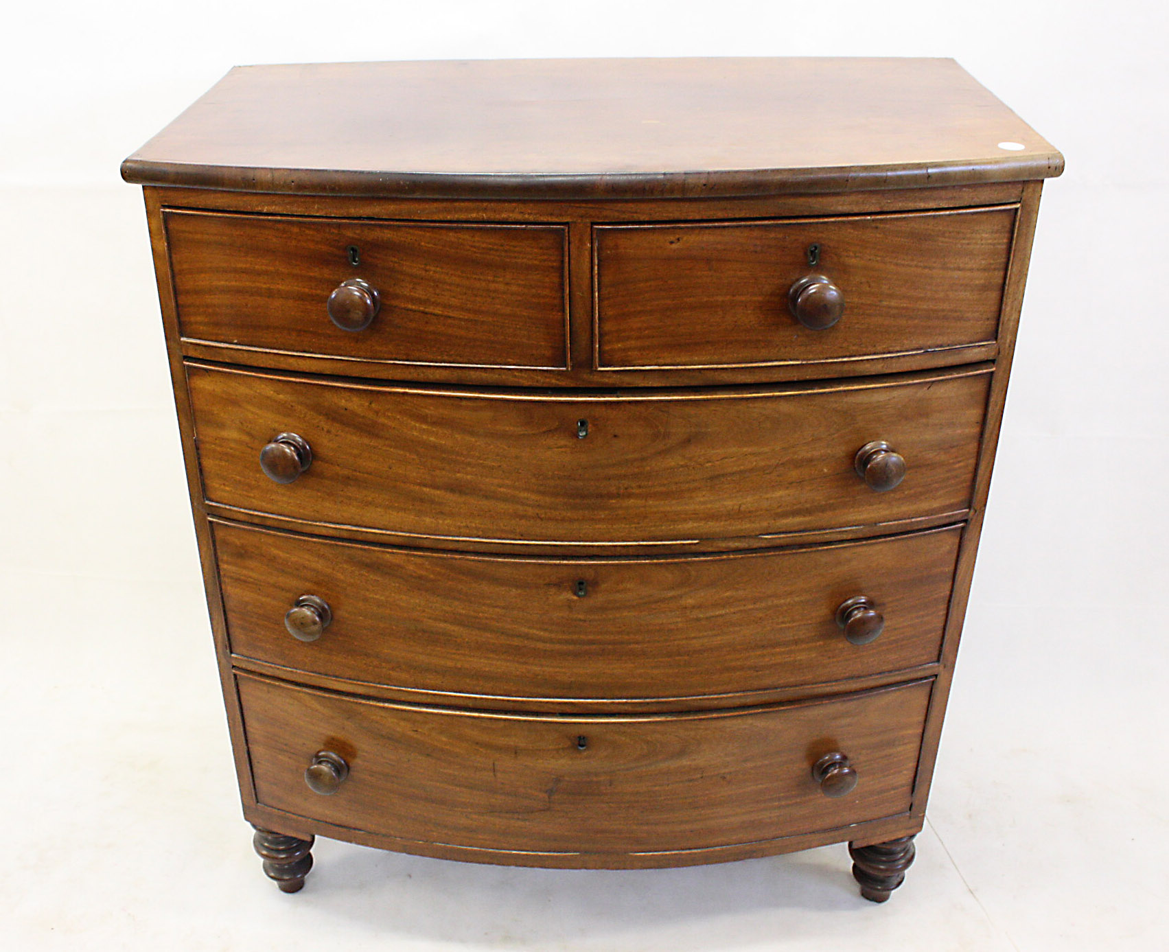 A 19th Century mahogany bow fronted chest of drawers, having two short over three graduated long
