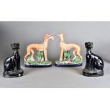 A pair of Staffordshire greyhound figures, modelled standing, one with hare in mouth, the other with