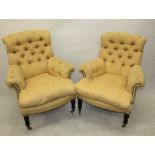 A pair of 19th Century button back easy armchairs, with feather cushions, ebonised supports, front