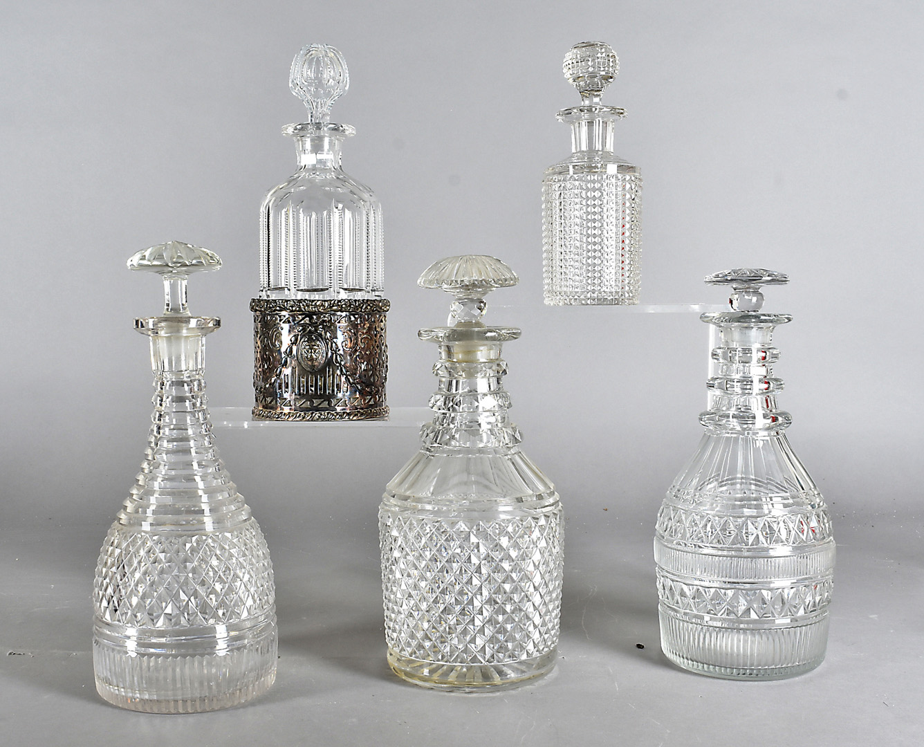 A group of five cut glass decanters and stoppers, all of various shape and design, together with a