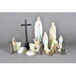 A collection of French pottery and porcelain figures, mostly the Madonna, together with an ebony and