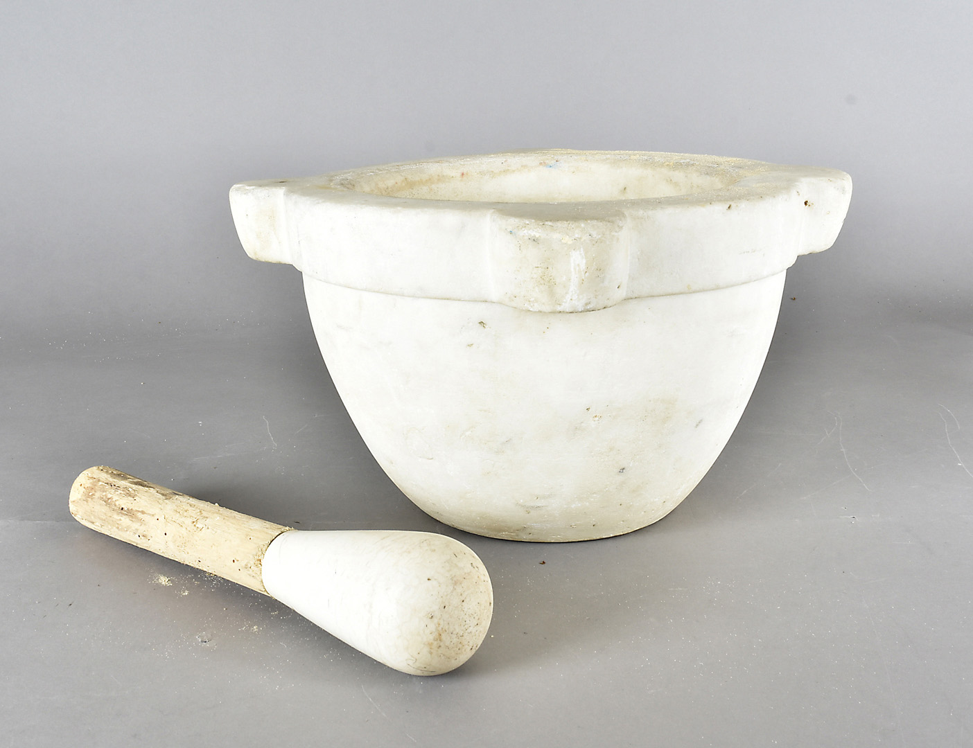 A large marble pestle and mortar, of circular form with four protruding demi lunes, 34 cm diameter x