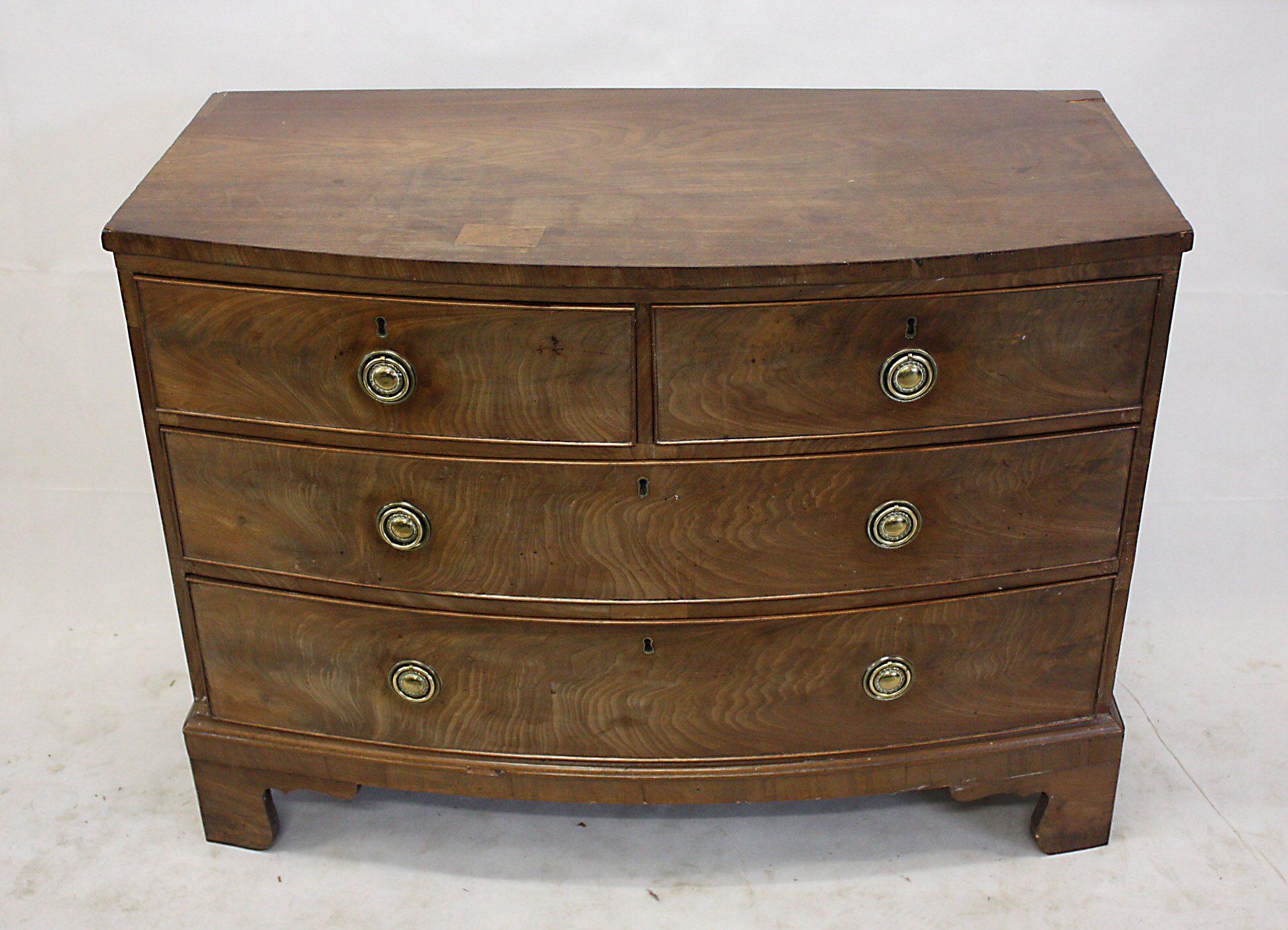 A 19th Century mahogany bow fronted chest of drawers, having two short over three long drawers on