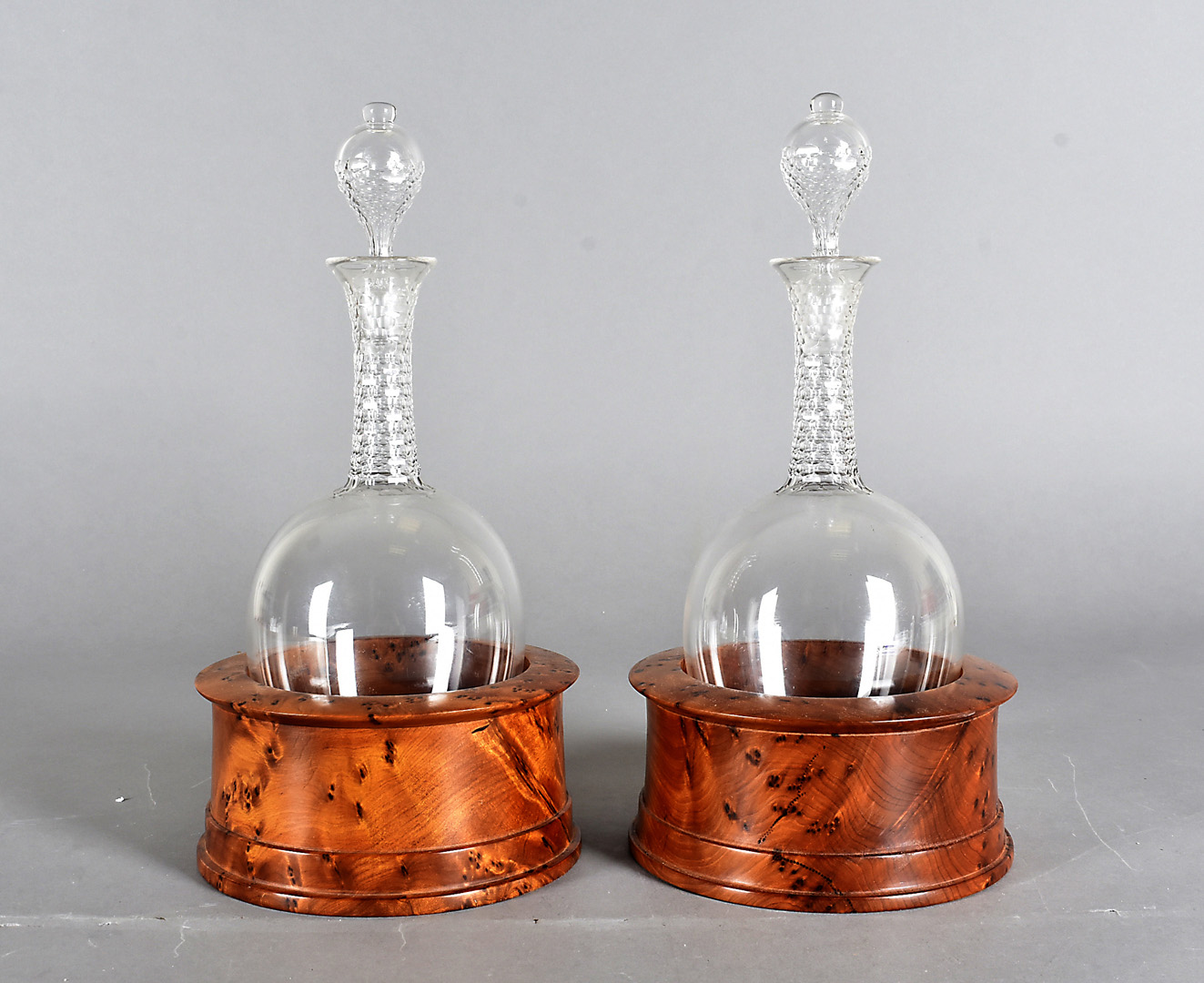 A pair of ovoid shaped decanters and stoppers, having elongated necks with cut glass decoration,