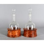 A pair of ovoid shaped decanters and stoppers, having elongated necks with cut glass decoration,