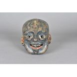 An Indian carved wooden face mask, modelled as a bald headed god with painted blue face and gold,