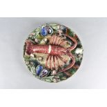 A continental stoneware lobster plaque, after Palissy, relief moulded with shellfish on a green