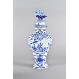A 19th Century Delft baluster vase and cover, the blue and white decorated body centred with a