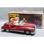Photoing on Car, tinplate battery operated toy car with lady taking photograph when it comes to a