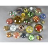 A collection of glass coloured paperweights, all having internal bubble and floral decoration