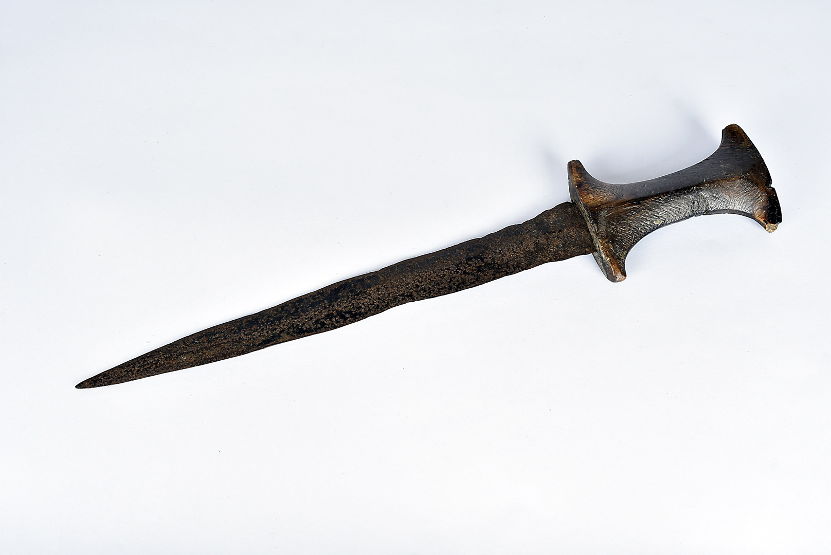 A late 17th/ early 18th Century tribal dagger, possibly African, having carved wooden handle, with