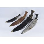 A group of four Kukri knives, all various sizes, one having a decoration white metal case, with