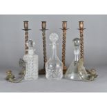 A set of four copper barley twist candlesticks, three decanters, and two wall mounted candlesticks