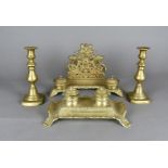 A brass inkwell and letter rack, decorated with cherubs and floral design, together with a brass