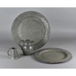 Two 18th Century pewter circular trays, 46 cm and 40 cm diameter, a 19th Cenutry hot water jug and a