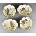 A pair of Limoges porcelain plates, decorated with a pair of birds within foliage together with a