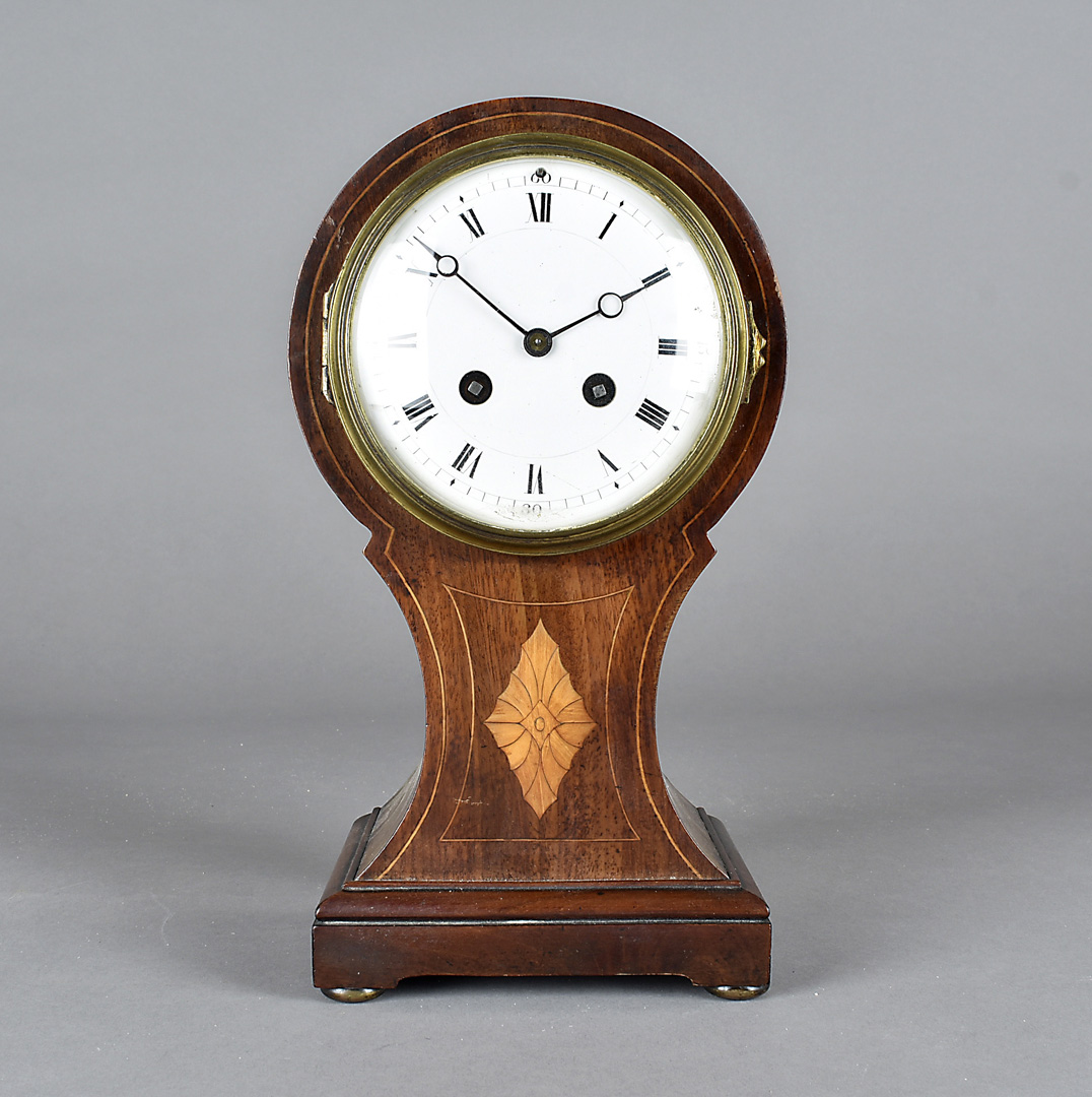 An Edwardian hour glass shaped mahogany and satin strung mantel clock, with eight day French drum