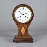 An Edwardian hour glass shaped mahogany and satin strung mantel clock, with eight day French drum