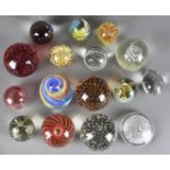 A collection of British and European coloured and colourless glass paperweights, three of egg