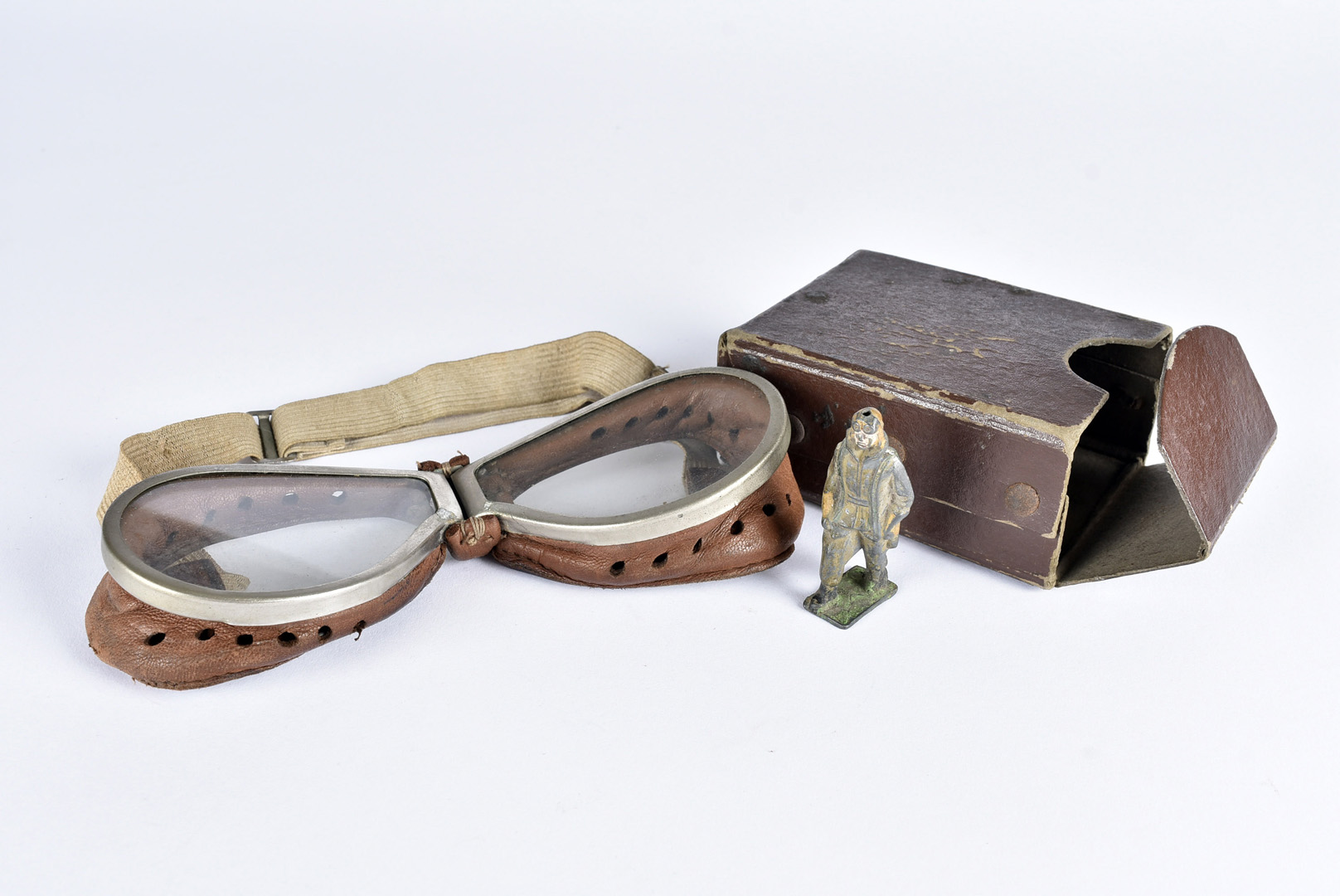 A pair of vintage driving/aviation goggles, having white metal rims with leather sides and