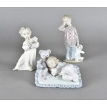 A Lladro figure of sleeping girl with her Teddy Bear, and two Nao figures of children