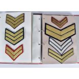 Two folders containing a collection of military rank chevrons, comprising Lance Corporal,