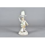 A KPM porcelain figural candlestick, modelled as a fashionable boy selling grapes, 19.5 cm high