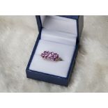 A modern 9ct gold and pink sapphire dress ring from Rocks & Co, having three rows of oval Ceylon