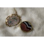 A Victorian pinchbeck and agate brooch, together with an opaque hardstone brooch in yellow metal