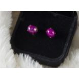 A modern pair of ruby earrings, the cabochon oval stones in 9ct gold stud mounts (2)