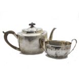 A Georgian style Victorian silver teapot and sugar basin, helmet shaped with engraved designs and