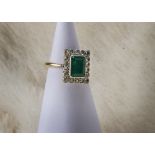An Art Deco period emerald and diamond cluster ring, the rectangular platinum tablet set with