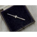 An Art Deco bar brooch, the white metal, probably platinum bar with half cut pearl to centre flanked