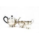 An Art Deco silver three piece tea set by EV, circular with bead rims and fluted lowers, Sheffield