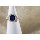 A modern 9ct white gold kyanite and diamond dress ring, oval blue stone in crossover mount with