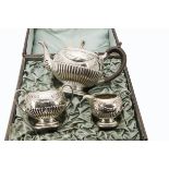 A three piece Victorian silver tea set by Charles Stuart Harris, presented in a tatty fitted box,