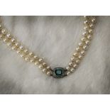 A two strand pearl necklace, the graduating white cultured pearls with silver and paste set clasp