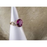 A modern 9ct gold and flaming pink topaz dress ring, large oval stone in mount with split