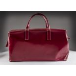 A 1980s red leather holdall from Tanner Krolle, having beige suedette inner, marked to outer,