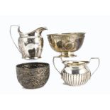 A group of four Georgian and Victorian silver tea related items, including a helmet shaped jug, a