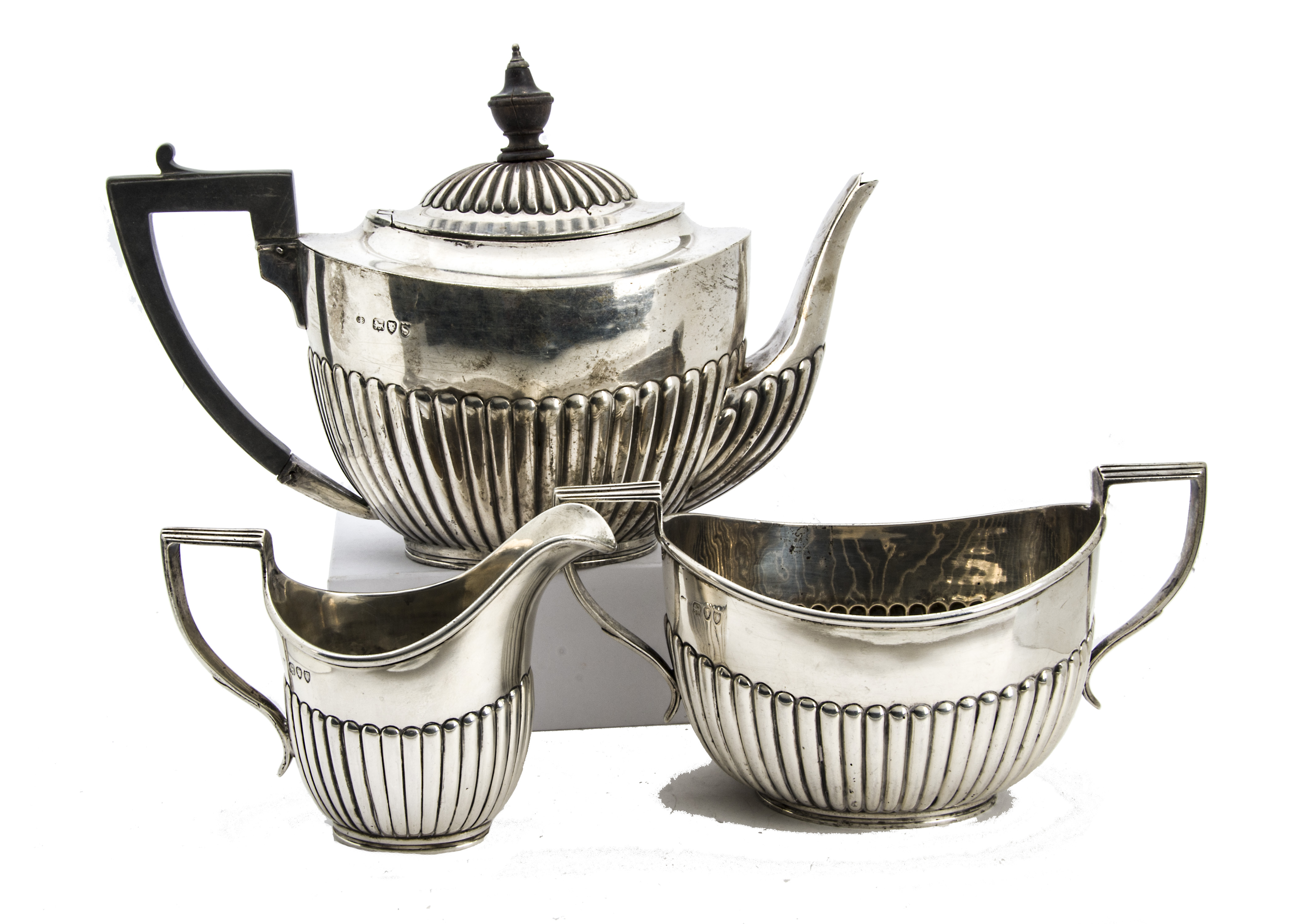 A Victorian silver three piece tea set by Charles Boynton, helmet shaped with fluted lowers,