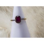 An Edwardian 18ct gold and ruby ring, the octagonal synthetic red stone in basket mount, shank