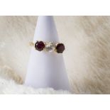 An 18ct gold gem set three stone ring, having a white topaz and pair garnets, marked 18ct, 4.4g